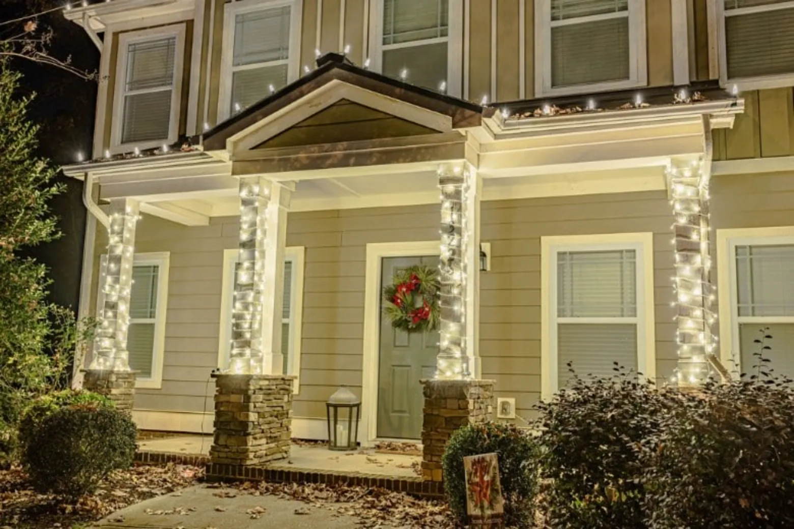 A cozy home is decorated with twinkling white lights and a festive wreath
