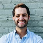 Young man with a beard smiling, showcasing positive reviews and friendly demeanor