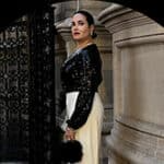 Woman in elegant attire poses gracefully near a decorative archway, highlighting positive reviews