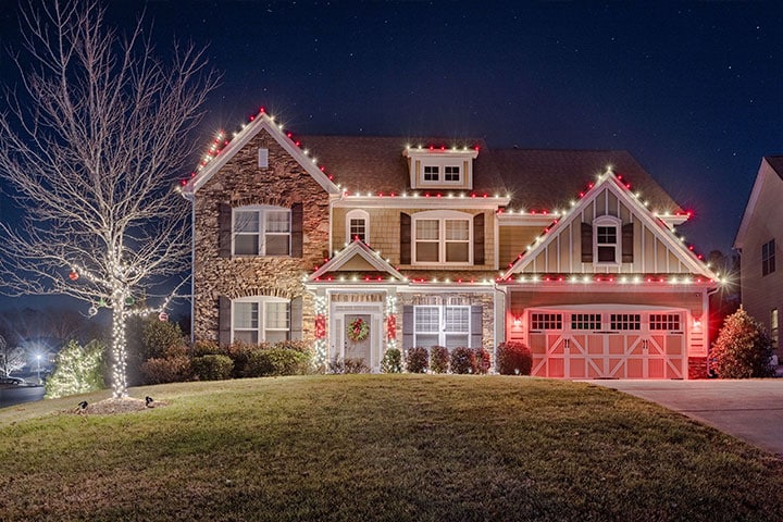 A beautifully decorated house adorned with festive lights shines brightly at night