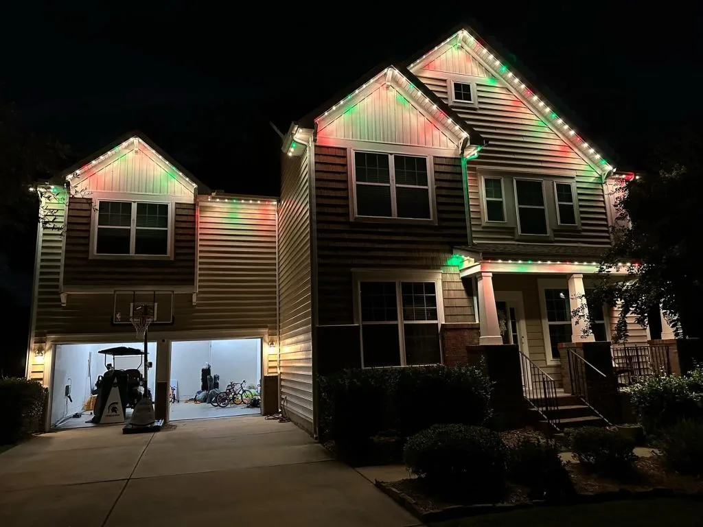 A beautifully decorated house shines with colorful Christmas lights at night