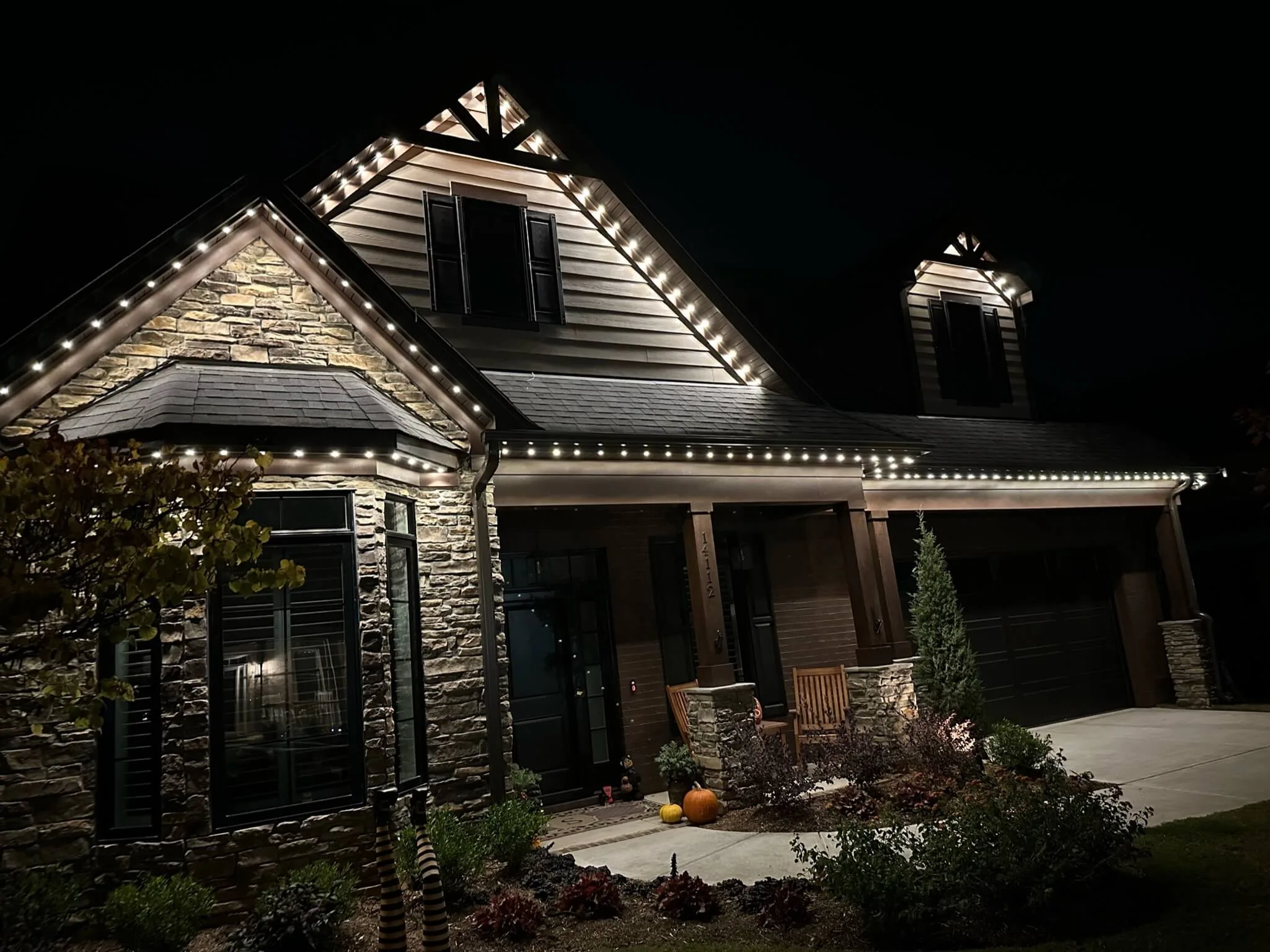 Locations feature a beautifully illuminated house adorned with decorative lights at night