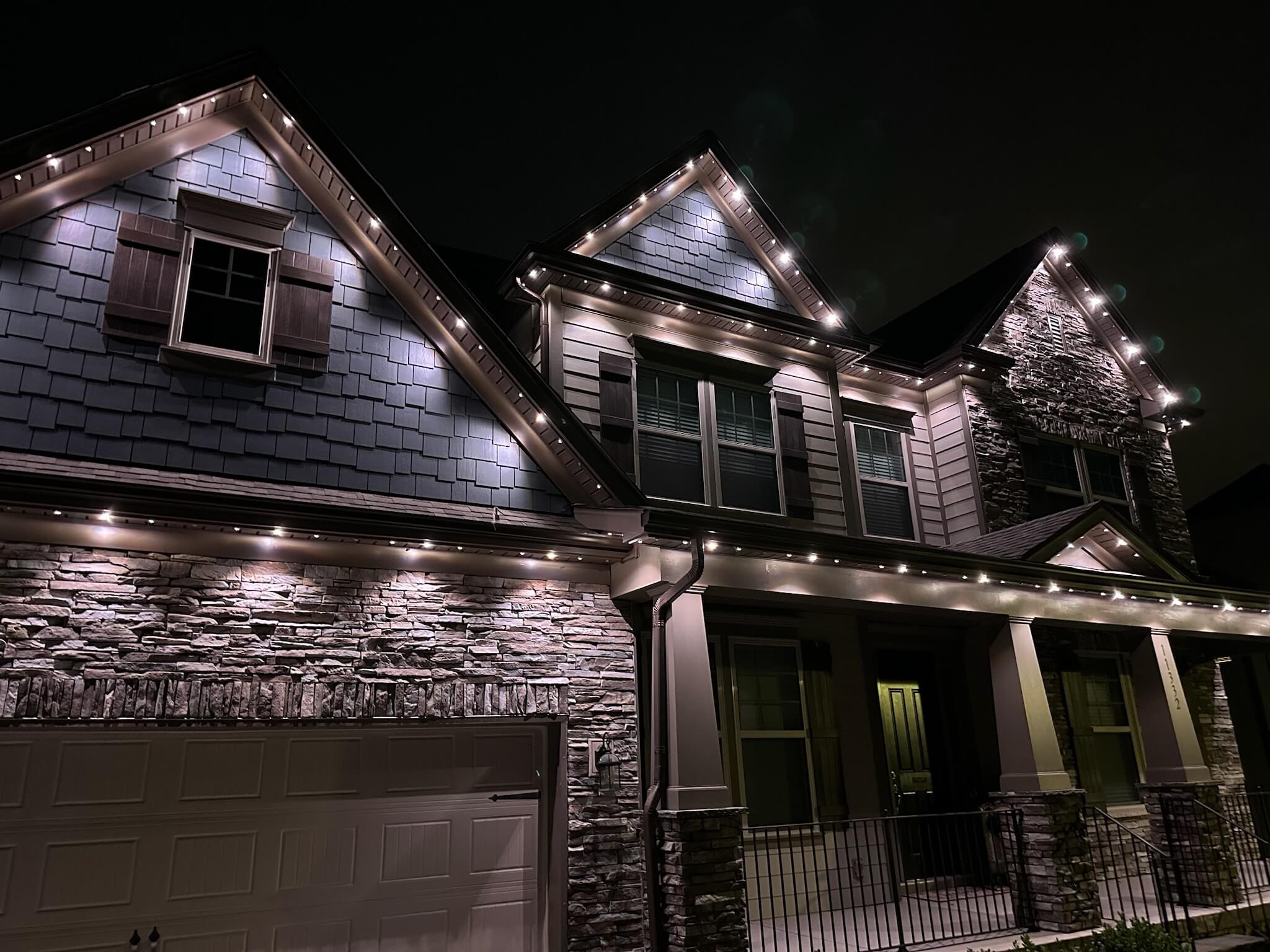 Locations featuring a beautifully lit house adorned with warm white string lights at night