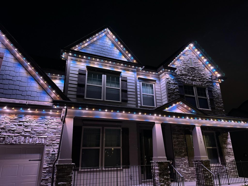 A beautifully illuminated house is adorned with colorful lights during the night