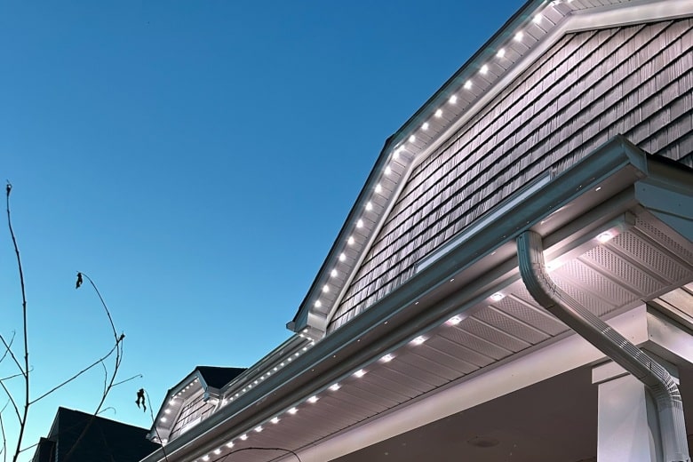 Soffit lighting twinkles along the roofline under a clear evening sky