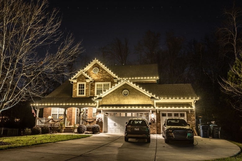 A beautifully decorated house illuminated with festive lights glows in the nighttime